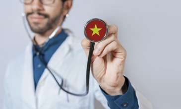 Doctor holding stethoscope with Vietnam flag. Vietnam health and care concept, Vietnam flag on