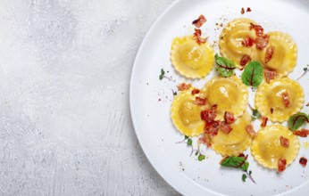 Fresh ravioli, with butter, spices and herbs, fried bacon, on the table, top view, light