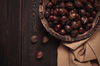 Roasted chestnuts, in a wooden plate, top view, homemade, no people