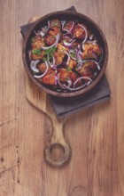 Fried meat, pork kebab, ketsi in a clay pan, with red onions and herbs, homemade, no people