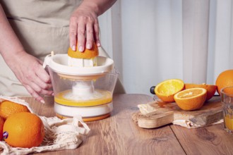 Preparation of freshly squeezed orange juice, using a juicer, in a cozy kitchen setting
