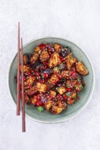 Fried eggplant, Chinese style, in sweet and sour sauce, with pepper and sesame seeds, in a green