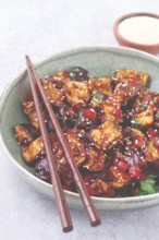 Fried eggplant, Chinese style, in sweet and sour sauce, with pepper and sesame seeds, in a green