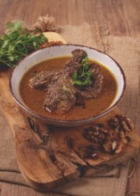 Fesenjan, an Iranian dish, stewed chicken, in a nut-pomegranate sauce, in a bowl, homemade, no