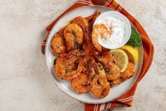 Fried white-footed shrimp, tiger prawns vannamey, on a plate, with lemon and herbs, no people