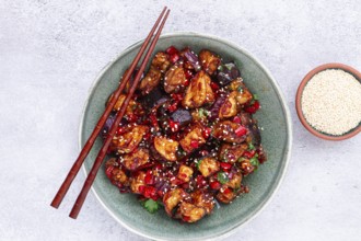Fried eggplant, Chinese style, in sweet and sour sauce, with pepper and sesame seeds, in a green