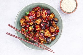 Fried eggplant, Chinese style, in sweet and sour sauce, with pepper and sesame seeds, in a green