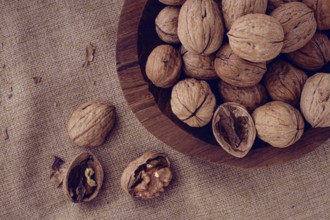 Freshly picked walnuts, in a wooden bowl, on a wooden table, rustic style, no people
