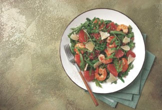 Fresh shrimp salad with arugula, grapefruit, and parmesan served in a bowl