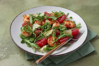 Fresh shrimp salad with arugula, grapefruit, and parmesan served in a bowl
