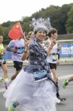 A runner with the flag of the People's Republic of China on the Great Star at the 51st BMW Berlin
