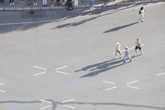 Runners with long shadows on the big star seen from the Victory Column at the 51st BMW Berlin