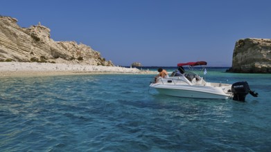 Motorboat drifting in the clear blue sea in front of a rocky coastline, White Cliffs, White Beach,