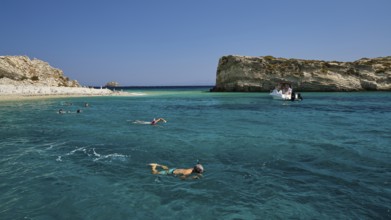 People swimming in the open sea, a boat approaches the rocks, White Cliffs, White Beach, Makri