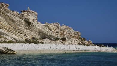 Rocky coastal landscape with a clear blue sky and calm turquoise water, White Cliffs, White Beach,