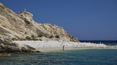 A rocky coastline with clear turquoise waters under a clear blue sky, White Cliffs, White Beach,