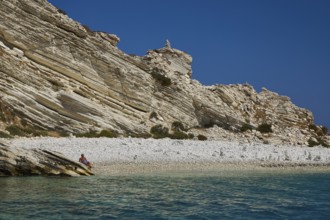 A rocky coastline with clear views of turquoise waters and a blue sky, White Cliffs, White Beach,