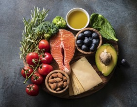 A vibrant assortment of healthy food ingredients, including fresh vegetables, salmon, nuts, and