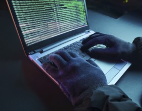 Cybersecurity threat depicted by gloved hands operating a computer, commands displayed on the