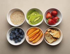 An arrangement of bowls filled with an assortment of fresh fruits, nuts, and seeds, showcasing a