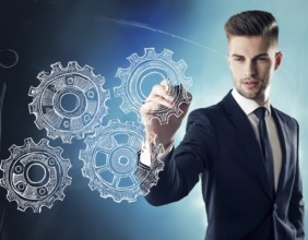 Businessman in formal attire holding stylized metallic gears against a blue futuristic background.