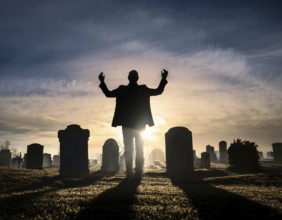 A silhouette of a lone figure walking off a gravestone, The scene evokes Resurrection thoughts
