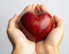 Close-up of hands holding heart-shaped fruit, symbolizing healthy lifestyle, love, nutrition,