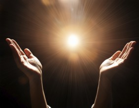 Image of open hands embracing a radiant light source, embodying concepts of hope, spirituality, and