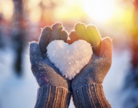 Serene winter scene showcasing hands in gloves holding a snow heart symbolizing love and warmth, AI