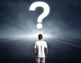 A person stands in contemplation near a large glowing question mark on an open grassy plain,