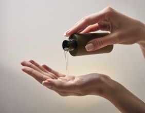 A close-up view of hands pouring a creamy lotion from a bottle into a palm. The scene emphasizes