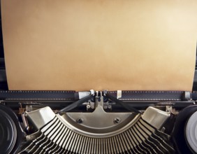 View from above of a retro typewriter equipped with a blank paper sheet, representing creativity,