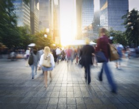 A dynamic scene featuring blurred people walking in a city street surrounded by skyscrapers and
