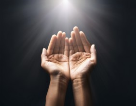 Individual Worship at Home. Image of open hands embracing a radiant light source, embodying