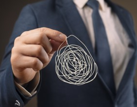A close-up of a professional ipresenting a piece of intricate, tangled wire, symbolizing
