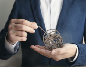 A close-up of a professional ipresenting a piece of intricate, tangled wire, symbolizing