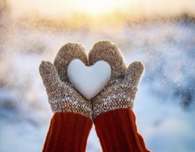 Serene winter scene showcasing hands in gloves holding a snow heart symbolizing love and warmth, AI