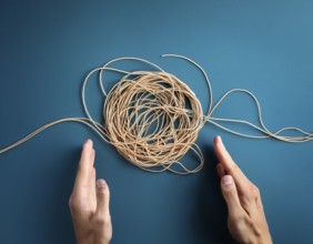 A close-up of a professional ipresenting a piece of intricate, tangled wire, symbolizing