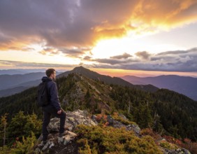 Traveler with backpack overlooking mountain valley at sunrise, symbolizing adventure, exploration,