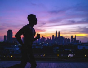 A cinematic silhouette of an athletic man running, representing fitness, endurance, wellness, and