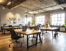 Modern coworking space with laptops, coffee cups, plants, and daylight showcasing minimal interior