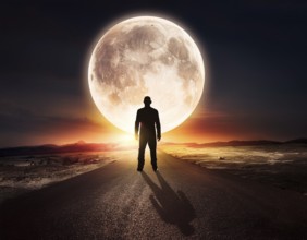 Man silhouette with giant glowing moon in night sky, symbolizing reflection, cosmic mystery, and