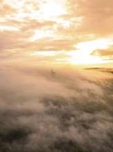Castle appears through thick fog, surrounded by golden sky light, Lichtenstein Castle,