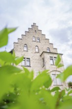 An impressive historic building in Gothic style, half hidden by green plants, Lichtenstein Castle,
