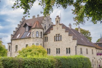 An old building with a red tiled roof and many windows, surrounded by trees, Lichtenstein Castle,
