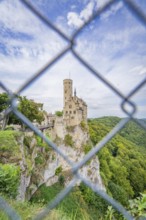 Castle on a hill seen through a lattice, surrounded by forest, Lichtenstein Castle, Lichtenstein,