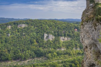 Lush forest landscape with steep rock faces and a vast green panorama in the distance, Lichtenstein