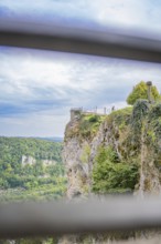 Spectacular cliff view with green landscape and wide sky in the background, captured from a railing