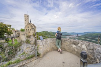 Person admires castle and wide, wooded landscape from the vantage point, Lichtenstein Castle,