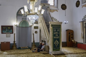 Mosque interior with seating and illuminated chandelier, Ibrahim Pasha Mosque, Old Town, Turkish